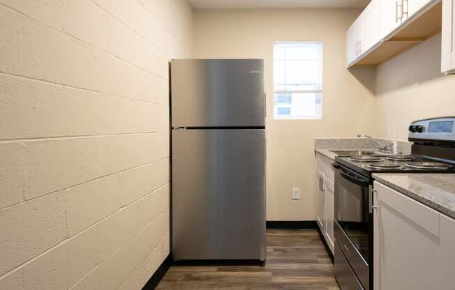 a kitchen with a refrigerator and stove and a window