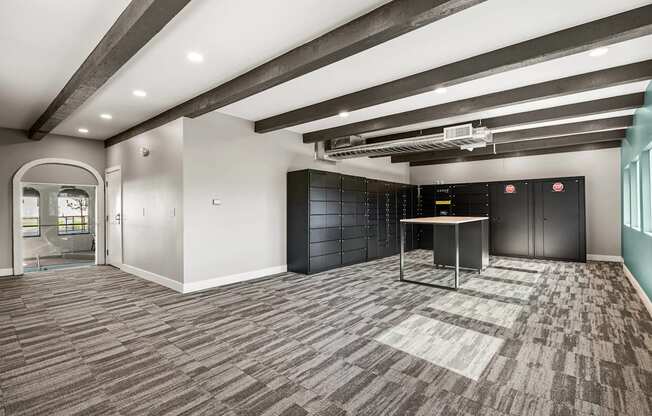 A room with a carpeted floor and a table with a black cabinet in the background.