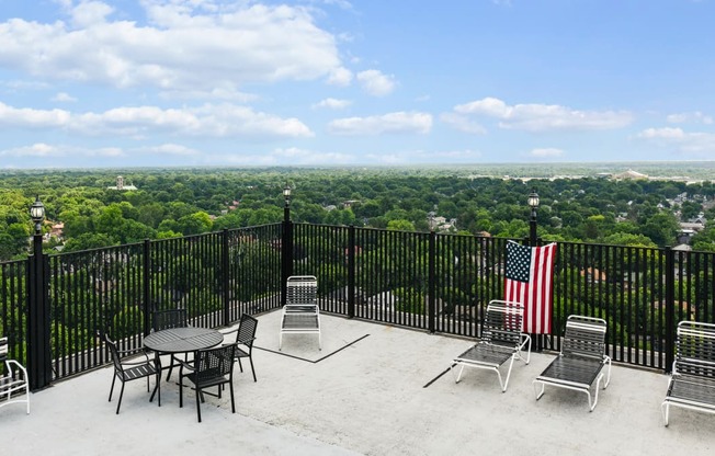 an outdoor patio with tables and chairs and an flag on a fence