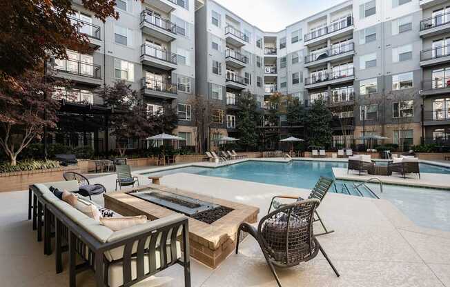 A large outdoor pool area with a table and chairs.