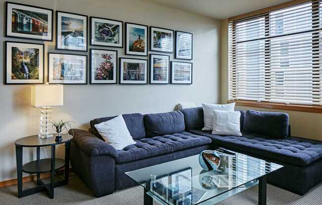 A living room with a blue couch and pictures on the wall.