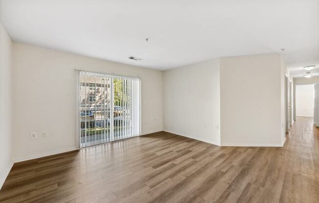 an empty living room with a door to a balcony