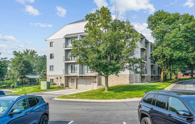 A blue car is parked in a parking lot in front of a building.