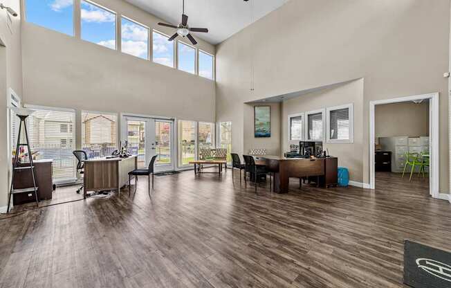 A room with a ceiling fan and a table with chairs.