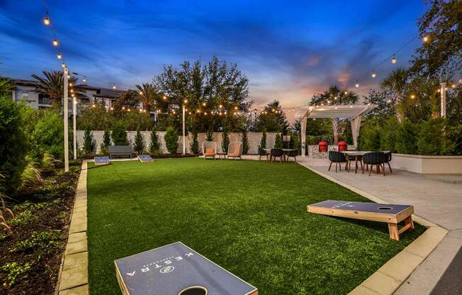 a backyard with a grassy lawn and tables and chairs