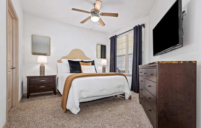 a bedroom with a bed and a ceiling fan