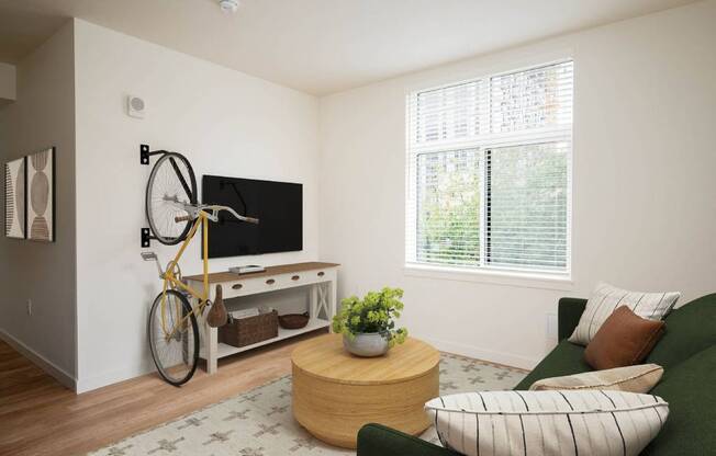 a living room with a green couch and a kitchen with a fan and a window