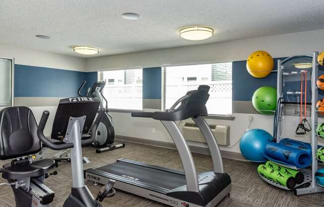 a gym with various exercise equipment at the enclave at university heights