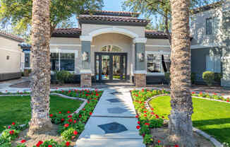 the front entrance of a home with palm trees and a walkway