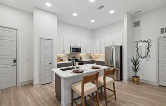 a kitchen with a white counter top and a stainless steel refrigerator