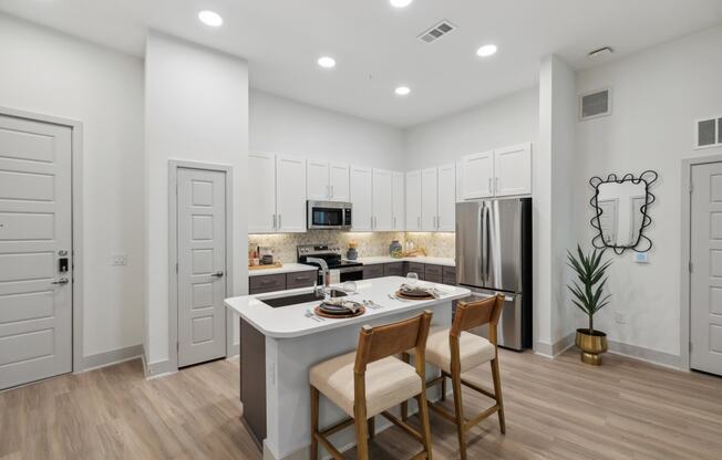 a kitchen with a white counter top and a stainless steel refrigerator