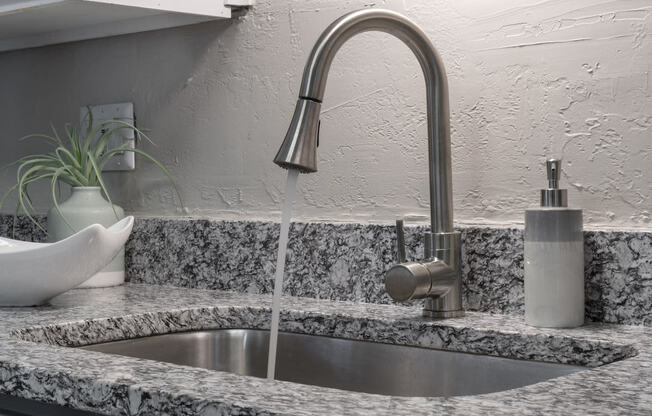 modern fixture with pull-down sprayer and under-mount sink in granite countertop in kitchen at Terraces at Clearwater Beach, Clearwater, Florida