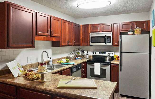 A kitchen with brown cabinets and a granite counter top.