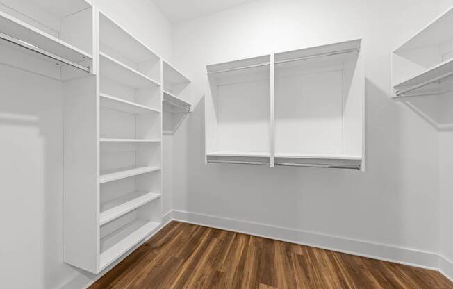 A white walk in closet with shelves and a sliding door.