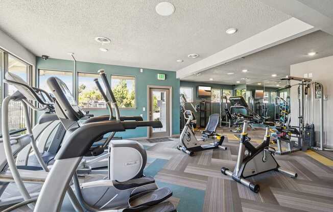A gym with treadmills, elliptical machines, and other exercise equipment.