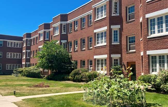 A red brick building with a green lawn in front.