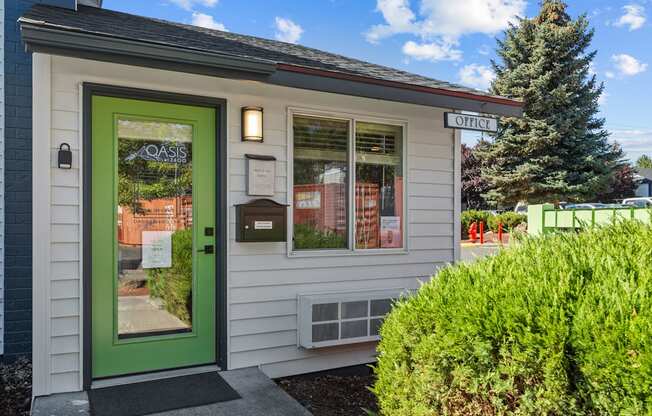 the front of a small building with a green door