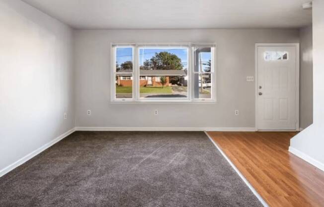A room with a view of a backyard through the window.