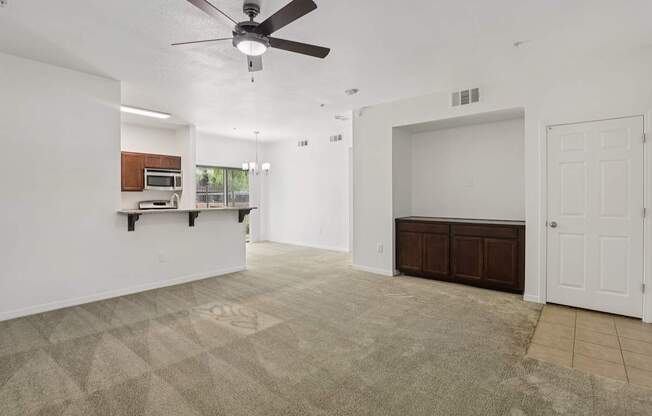 A room with a ceiling fan and carpeted floor.