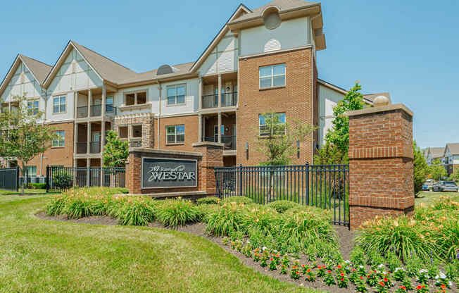 an apartment building with a sign in front of it