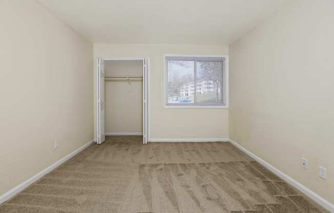 an empty living room with carpet and a window