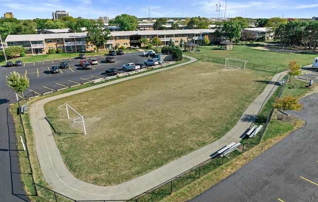 an aerial view of a park with a soccer field and a parking lot