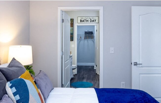 a bedroom with a bed and a hallway with a bathroom