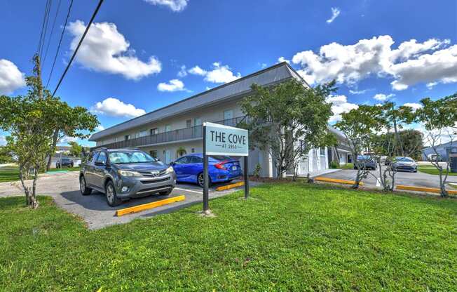 The Cove is a white building with a blue car parked in front.