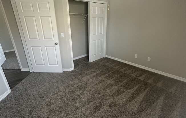 an empty room with a ceiling fan and a closet