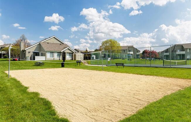 a volleyball court with houses in the background
