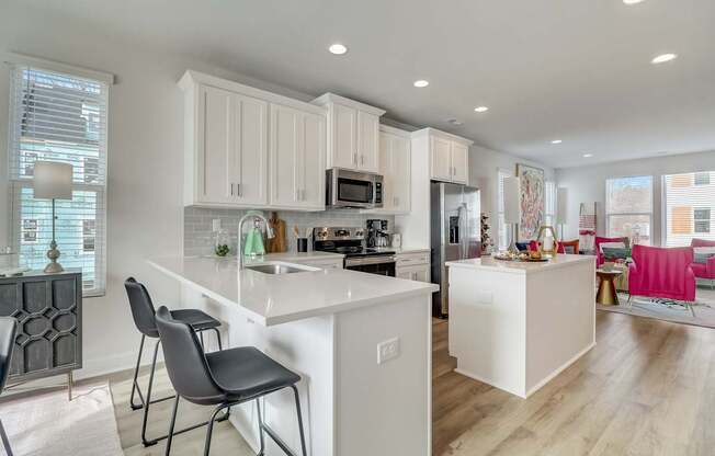 A modern kitchen with white cabinets and a large island.
