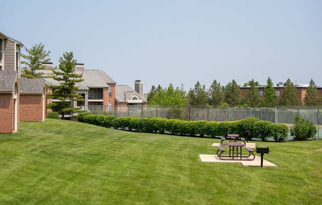 a large yard with a picnic table in the yard of a house