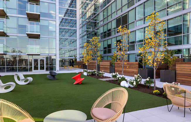 A modern outdoor seating area with wicker chairs and tables.