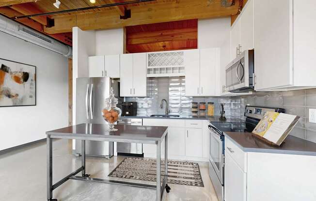 A kitchen with a refrigerator, oven, and microwave.