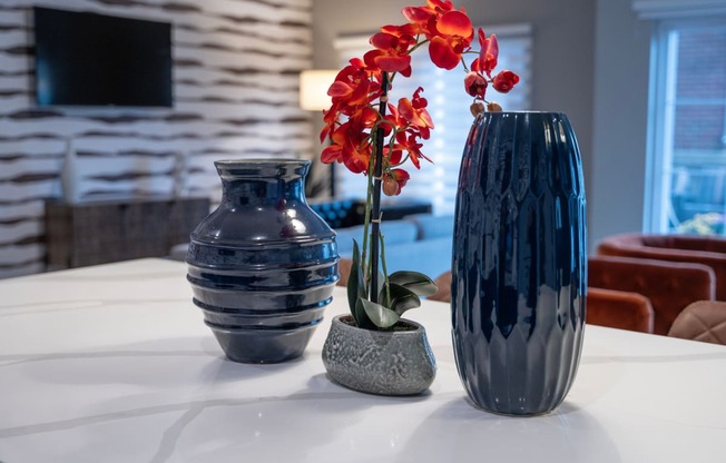 three vases and a flower on a table in a living room