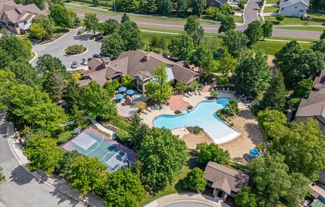 A bird's eye view of a residential area with a swimming pool and basketball court.