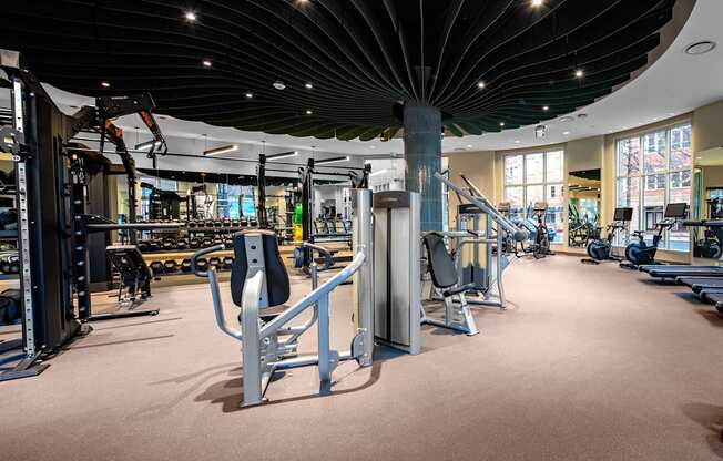 A gym with a variety of equipment including a weight bench, a leg press machine, and a treadmill.