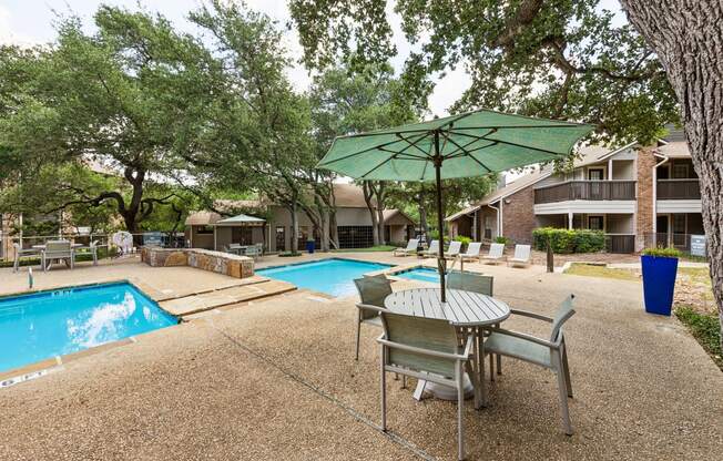 our apartments have a pool and a patio with a table and chairs