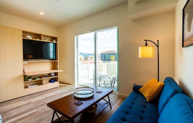 a living room with a blue couch and a television
