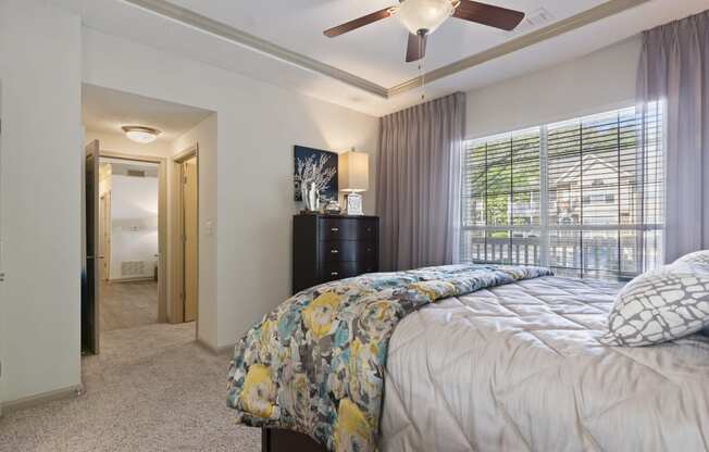 Bedroom with cozy bed in Model Apartment located at St. Andrews Apartments in Johns Creek, GA 30022