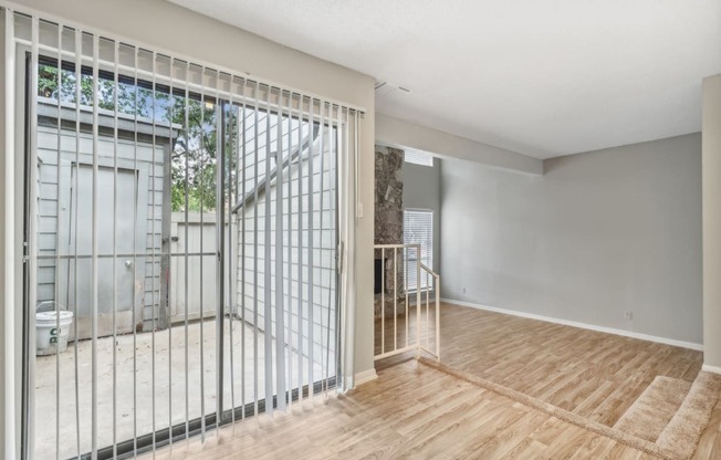 a living room with a sliding glass door to a balcony