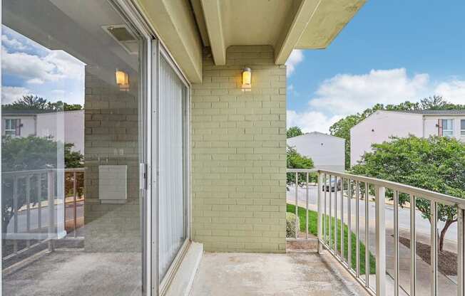 a balcony with a view of a brick wall and a glass door