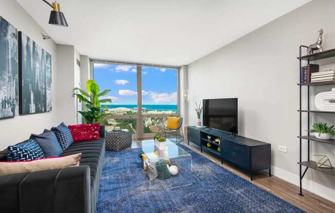 a living room with a couch and a tv and a view of the ocean