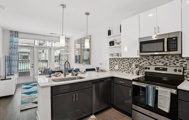 a kitchen with black and white appliances and a sink at Link Apartments® Mint Street, Charlotte, North Carolina