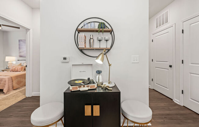 a living room with two stools and a table with a mirror