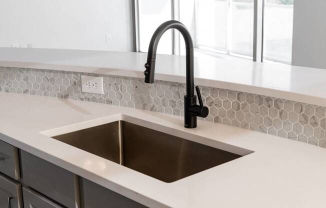 a kitchen with a sink and a black faucet