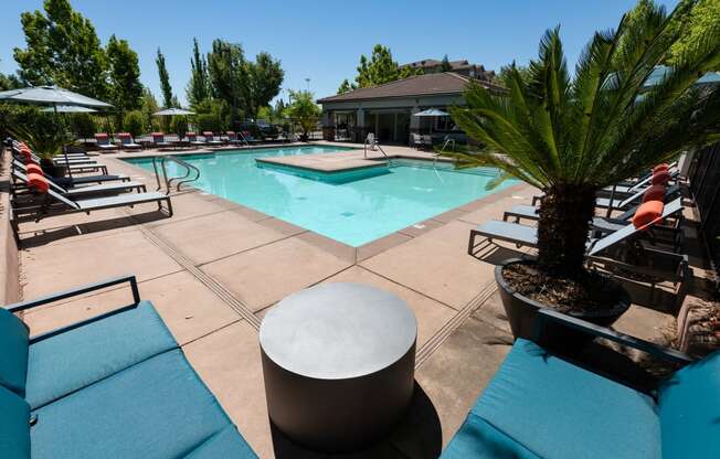 seating near expansive pool with surrounding lounge chairs and umbrellas