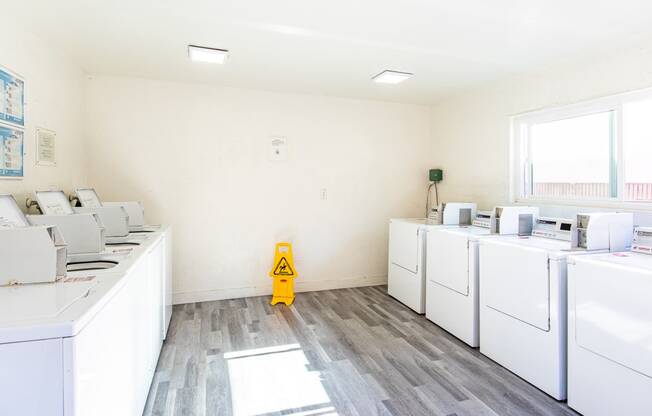 a room filled with washers and dryers and a yellow fire hydrant