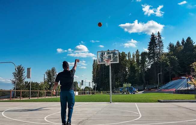 A man is playing basketball on an outdoor court.