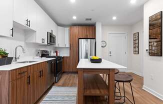 A modern kitchen with wooden cabinets and a white countertop.